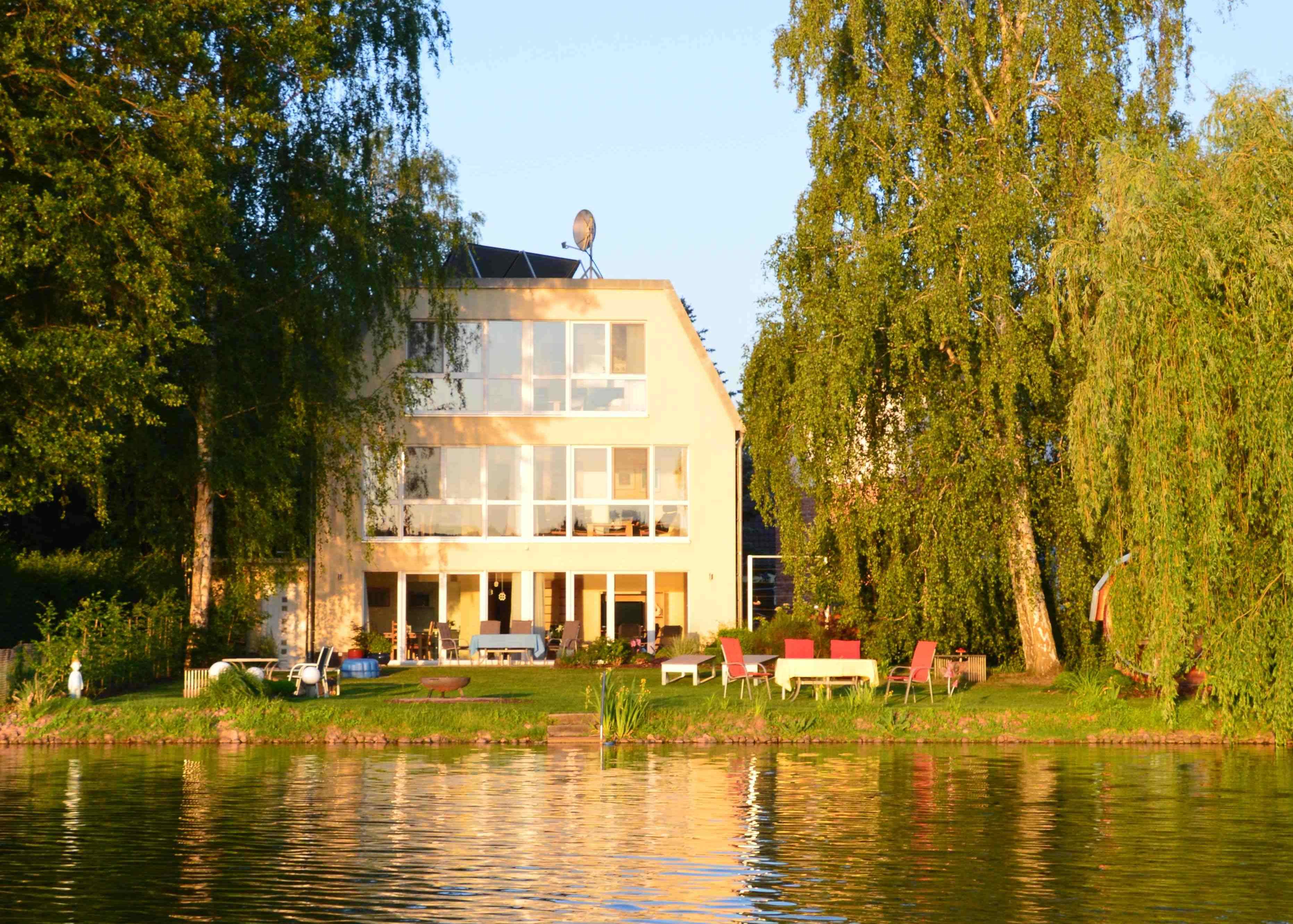 Ferienhaus direkt am See, Ansicht Seeseite mit der Liegewiese und dem Seeufer